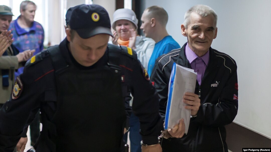 Yury Dmitriyev is escorted by a police officer upon his arrival for a court hearing in Petrozavodsk in June 2017.