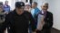 Yury Dmitriyev is escorted by a police officer upon his arrival for a court hearing in Petrozavodsk in June 2017.