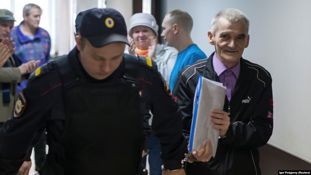 Yury Dmitriyev (right) is escorted by a police officer on his arrival for a court hearing in Petrozavodsk in June.