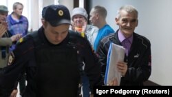 Yury Dmitriyev (right) is escorted by a police officer on his arrival for a court hearing in Petrozavodsk in June.