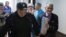 Yury Dmitriyev (right) is escorted by a police officer on his arrival for a court hearing in Petrozavodsk in June.