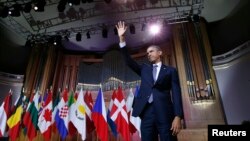 U.S. President Barack Obama waves after delivering a speech at Palais des Beaux-Arts in Brussels on March 26.