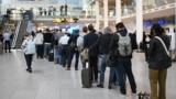 Passengers wait in line for new plane tickets at Copenhagen Airport on September 23, a day after unidentified drones disrupted flights at the aviation hub. 