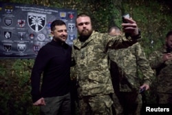 Un militar își face selfie cu președintele Zelenski în apropiere de Zaporijia, pe 13 noiembrie 2025.