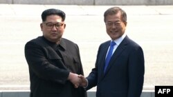Солтүстік Корея басшысы Ким Чен Ын (сол жақта) Оңтүстік Корея президенті Мун Чжэ Инмен қол алысып тұр. 27 сәуір 2018 жыл. 