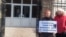Наталья Баранова держит в руках плакат