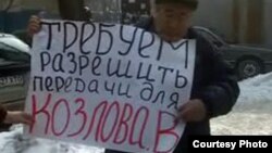 Активист незарегистрированной оппозиционной партии "Алга" Мухтар Жиенбаев проводит одиночный пикет у здания ДКНБ. Алматы, 15 февраля 2012 года.