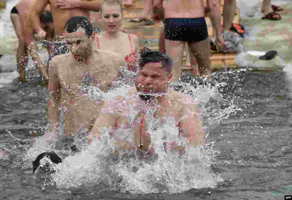 Christian Orthodox believers run into the freezing waters of the Dnipro River in Kyiv during the traditional holiday of Epiphany on January 19. (AFP/Genya Savilov)