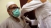 A man receives the Indian version of the AstraZeneca coronavirus vaccine from health officials at a hospital in Kabul.