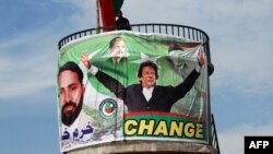 A Pakistani policeman stands guard on top of a water tank during an election campaign meeting by cricket legend and Pakistan Tehrik-e Insaaf party leader Imran Khan in the northwestern town of Mansehra on May 3.