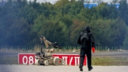 A police officer in protective clothing walks next to an explosive-disarming robot at Leipzig/Halle Airport in Schkeuditz, Germany, early last month after a drone was found near a runway. 