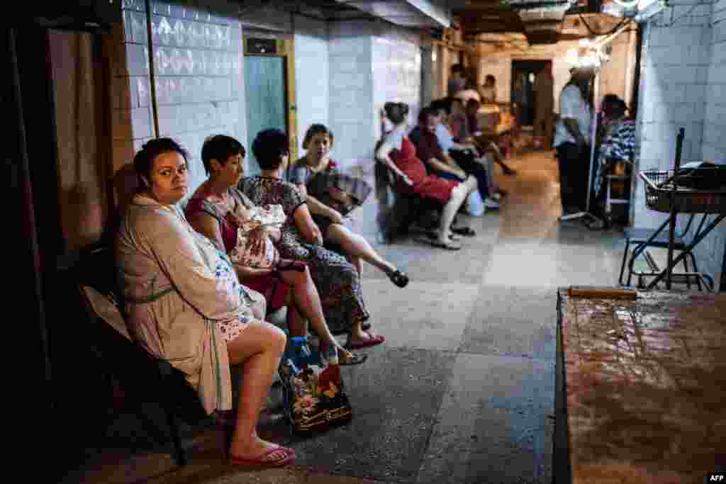 People sit inside a bomb shelter in a maternity hospital during shelling in Donetsk on August 11. (AFP/Dimitar Dilkoff)