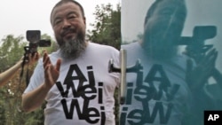 Activist artist Ai Weiwei speaks to journalists gathered outside his home in Beijing in June, after nearly three months of detention.