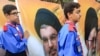 Shiite Muslim-affiliated members of the scout movement march with large portraits depicting the Iran's Supreme Leader Ayatollah Ali Khamenei (front) and the leader of Lebanon's Shiite movement Hezbollah Hassan Nasrallah during the funeral of a member of t