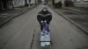 A woman on deserted street returns from collecting drinking water in the frontline town of Rodynske, near Pokrovsk in the Donetsk region. 