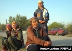 Женщины-оралманки сидят на обочине дороги в ожидании подённой работы. Село Жалгамыс Талгарского района Алматинской области, 17 октября 2011 года.