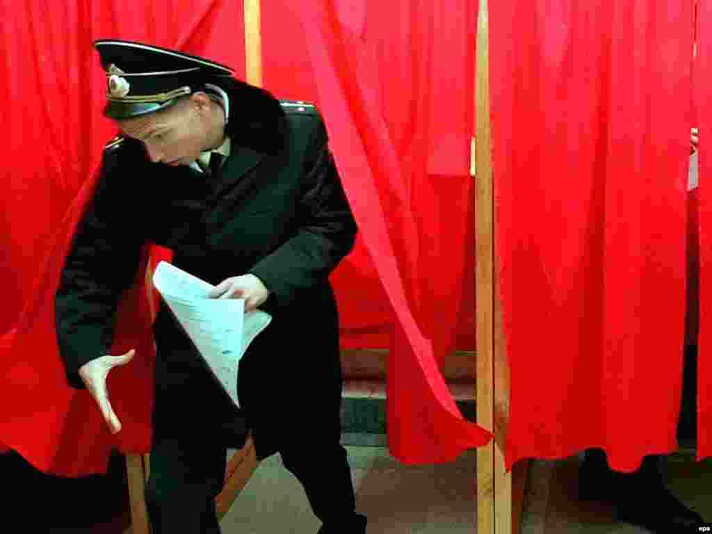 Over 100 million people are eligible to vote, some of them outside Russia. Here a sailor from Russia's Black Sea Fleet leaves a polling booth in Sevastopol, Ukraine. 