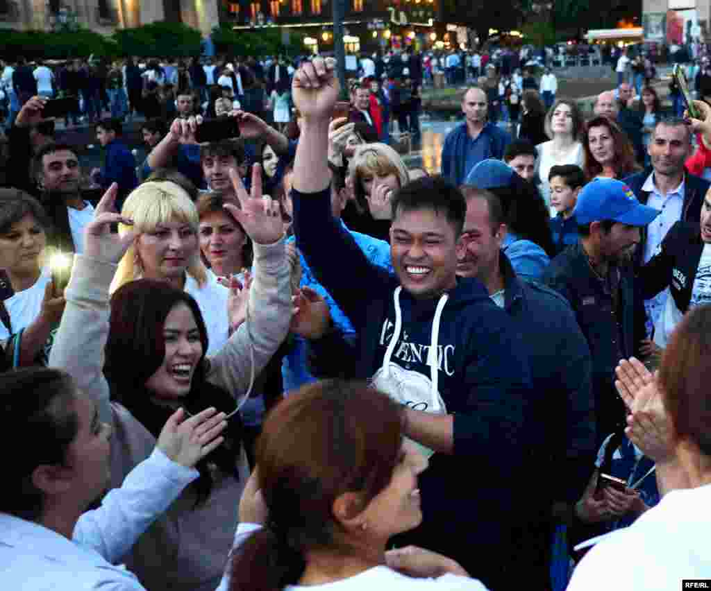 A couple from the Phillipines dancing on Republic Square. The husband told RFE/RL they were staying at a hotel near the square and decided to join the street celebrations: &quot;Why not? It looked like a good party.&quot;&nbsp;