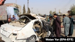 Afghan security officials inspect the scene of an IED blast in Lashkar Gah, the provincial capital of Helmand, which killed RFE/RL correspondent Mohammad Ilyas Dayee on November 12.