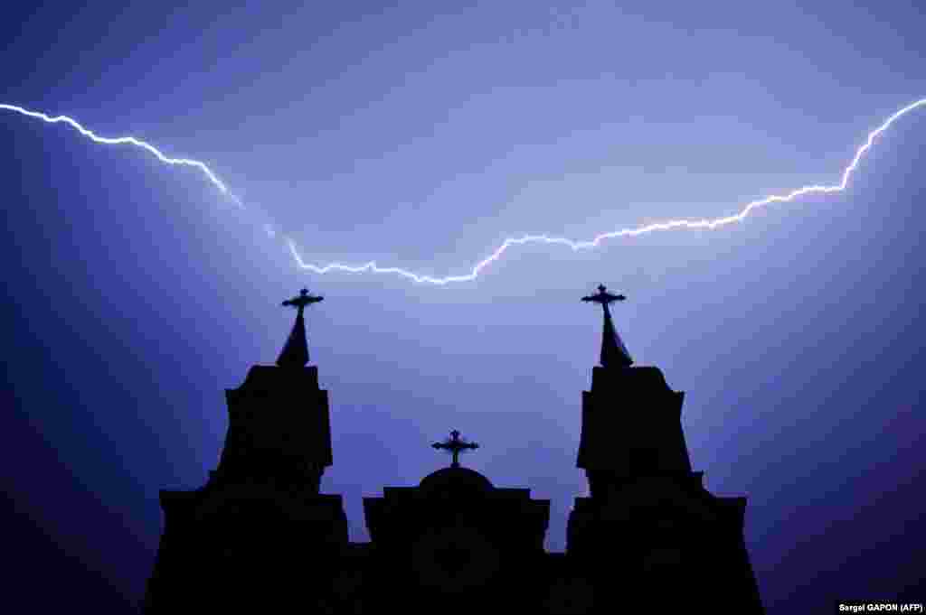 Lightning strikes above a Catholic church during a thunderstorm in the Belarusian village of Kreva, some 100 kilometers northwest of Minsk. (AFP/Sergei Gapon)