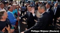 French President Emmanuel Macron waves as he leaves city hall after casting his ballot on June 18.