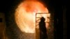 An employee in protective clothing maintains a steel-pouring ladle at the steel producer Salzgitter AG in Salzgitter, Germany. (AP/Markus Schreiber)