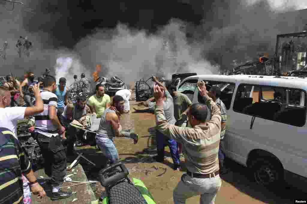 People react as they carry a dead body outside one of two mosques hit by explosions in the northern city of Tripoli, Lebanon. (Reuters/Omar Ibrahim)