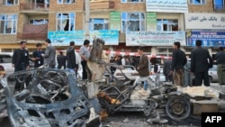 Afghan security personnel on April 16 cordon off the wreckage of cars in front of a building damaged by one of the Kabul attacks.