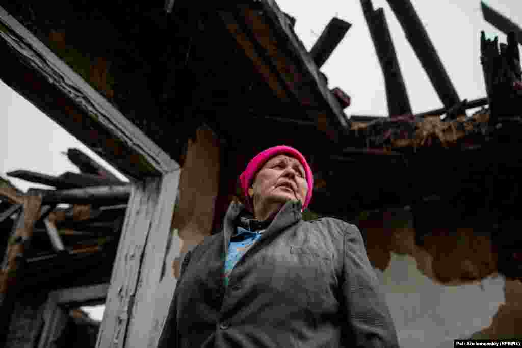 Demianenko stands inside the ruins of her house. 