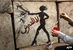 Граффити с надписью на арабском языке "Нет сексуальной агрессии!" на стене президентского дворца в Каире