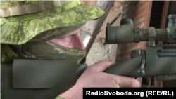 Український снайпер стежить за місцевістю крізь оптику прицілу