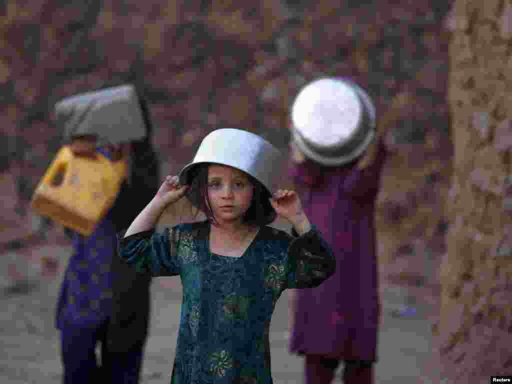 Fëmijët shkojnë për të marrë ujë në një burim në periferi të Islamabadit, Pakistan... 