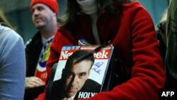 Сторонница Майка Хакаби держит журнал Newsweek c его автографом