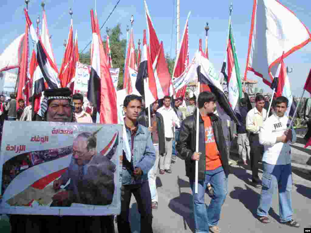 Iraq approves SOFA agreement; U.S. troops to leave by end of 2011. - An Iraqi demonstrator displays a poster of Iraq's Prime Minister Nuri al-Maliki during a march in Basra, southern Baghdad , Iraq on 19 November 2008. Hundreds of people took to the streets of Basra to support the recently signed security agreement between the Iraqi and the U.S. government .