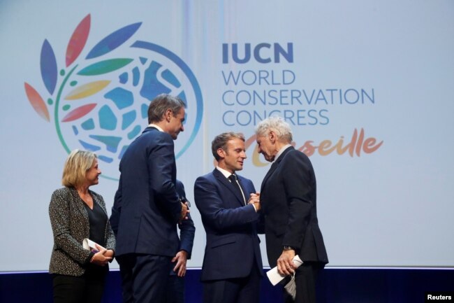امانوئل مکرون در همایش اتحادیه جهانی حفاظت از طبیعت در حال استقبال از هریسون فورد، سوم سپتامبر ۲۰۲۱
