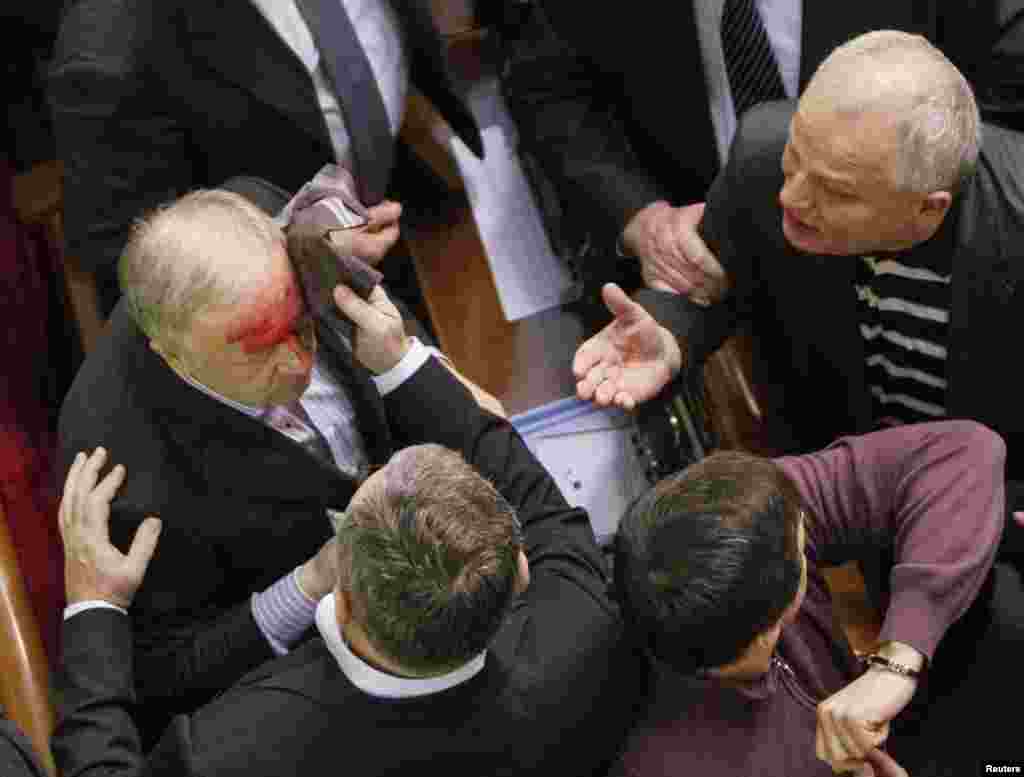 Ukrainian pro-government lawmaker Vladimir Malyshev is hurt during scuffles in parliament over an antiprotest law and other controversial legislation, which was passed on January 16. (Reuters/Gleb Garanich)