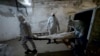 Иллюстративное фото. Патологоанатомы в защитных костюмах несут тела погибших от коронавируса. Морг больницы в  Бишкеке