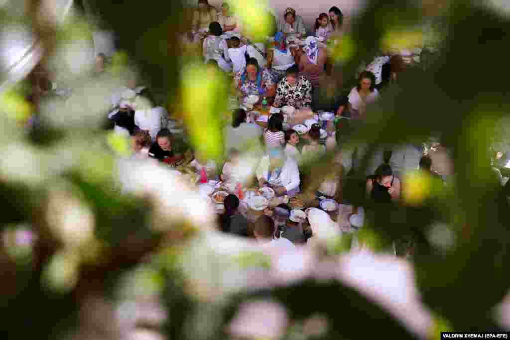 Guests sits down to enjoy an outdoor wedding feast.