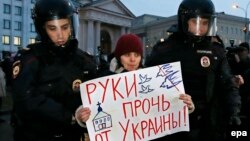 Полицейские задерживают участника антивоенного марша в Москве. 4 марта 2014 года.