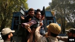 Supporter of an independent Kashmir lawmaker, Abdul Rashid Sheikh shout slogans from an Indian Police vehicle after they were detained during a protest march in Srinagar, the summer capital of Indian Kashmir, on September 26.