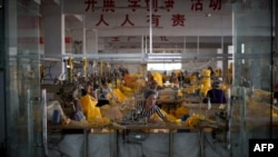 Women work on the protective suits for use in handling people infected with the Ebola virus.