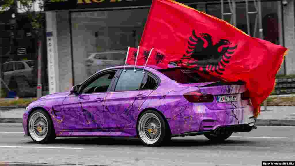 Një veturë me targa të Tetovës shihet duke lëvizur në Prishtinë, teksa në të janë vendosur disa flamuj kombëtarë shqiptarë. 