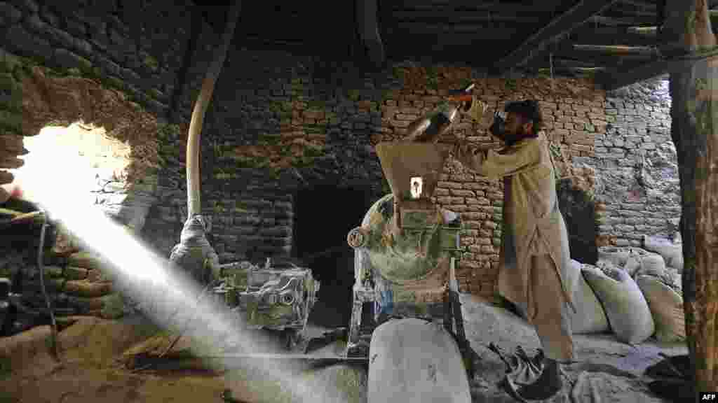 An Afghan laborer grinds wheat at a traditional mill in the Nahr-e Shahi district of Balkh Province on July 16. (AFP PHOTO/Qais Usyan)