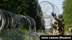 Litván katonák szögesdróttal erősítik a Belarusszal közös határt 2021. július 9-én