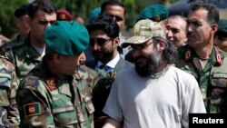Ali Haider Gilani, (R) son of former Pakistani prime minister Yusuf Raza Gilani, shakes hands with Afghan Joint Chief of Staff Gen. Qadamshah Shahim after he was rescued in Afghanistan in a joint operation by Afghan and U.S. forces on May 10.