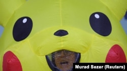 A demonstrator in a Pikachu costume reacts as global environmental activists protest against the gas industry during the United Nations Climate Change Conference (COP29) in Baku.