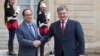 Президент Франции Франсуа Олланд приветствует президента Украины Петра Порошенко на ступенях Елисейского дворца