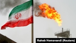 An oil production platform in the Soroush oil fields is seen alongside an Iranian flag in the Persian Gulf. 