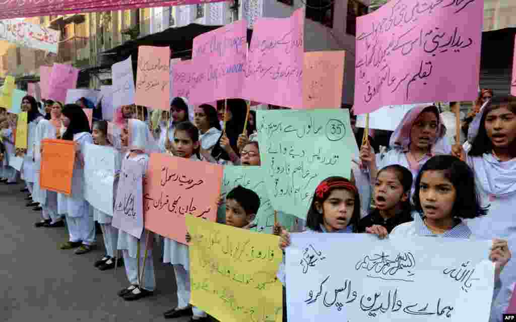 Students of Farooqi Girls&#39; High School wave placards as they stage a protest in Lahore on November 3, demanding the reopening of their school after it was set on fire by an angry mob that alleged the school gave a test that insulted the Prophet Muhammad.
