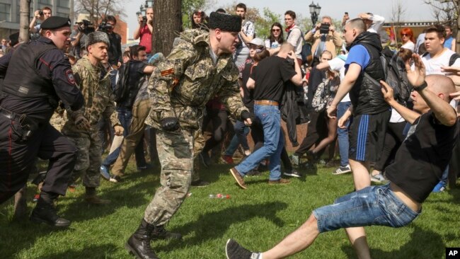 Человек в камÑÑлÑжной ÑоÑме и папаÑ
е бÑÐµÑ ÑÑаÑÑника акÑии "Ðн нам не ÑаÑÑ" на ÐÑÑкинÑкой плоÑади в ÐоÑкве, 5 Ð¼Ð°Ñ 2018 года